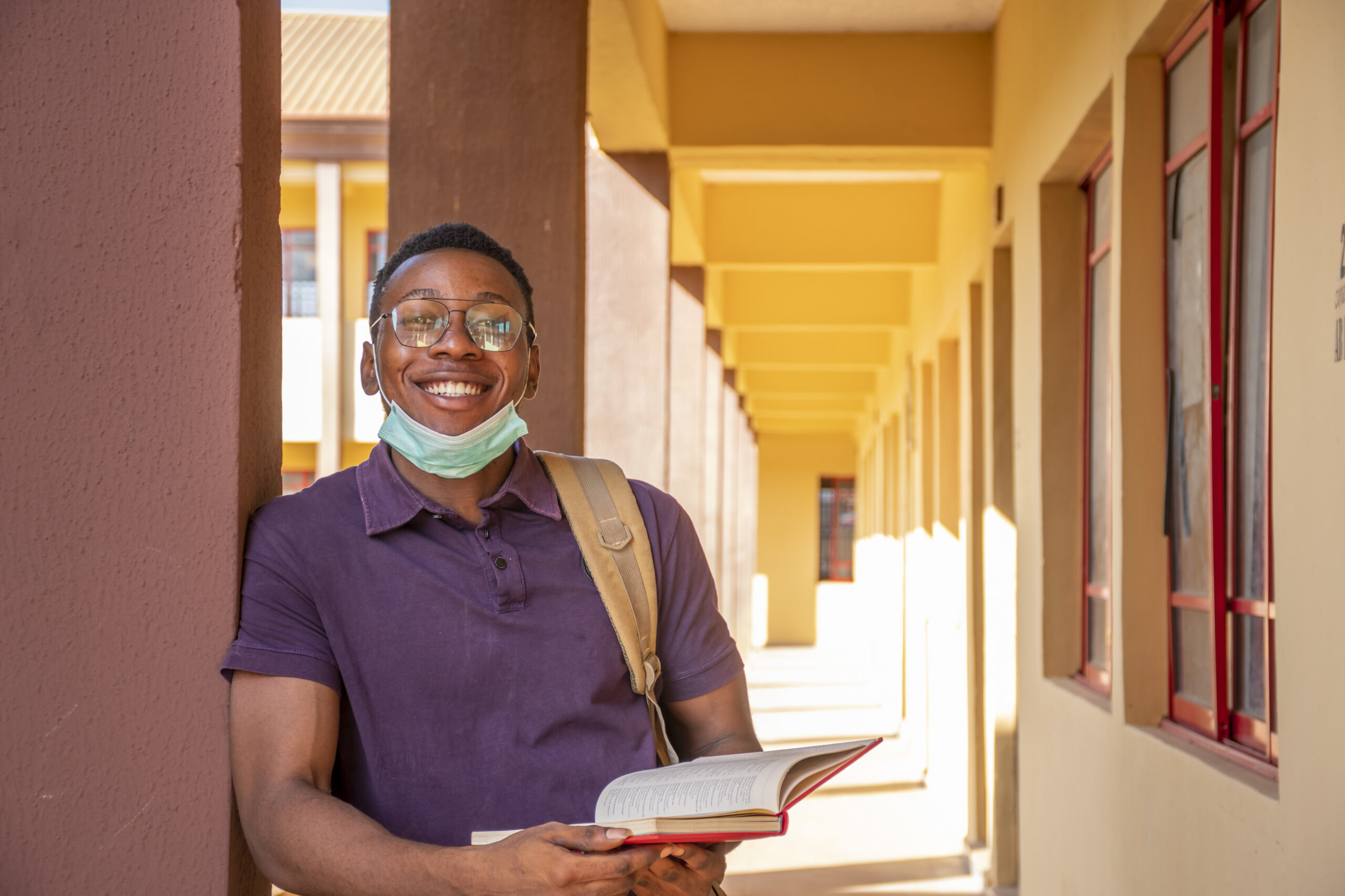 portrait smiling male student holding book smiling scaled 1